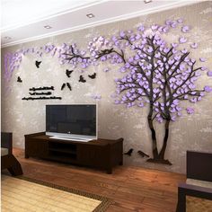 a living room with purple flowers on the wall and a large tree painted on the wall