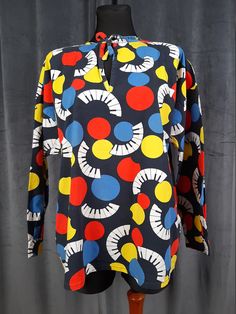 This is a beautiful vintage blouse made from cotton in the nineties. The pattern of the blouse is bright and colourful piano keys and circles. Perfect for music lovers! Excellent for your bohemian outfits! MAKE: This blouse was found in a Scandinavian vintage boutique which sells things made there. CONDITION: Good, there is a tiny rub on the blouse, see the last picture COMPOSITION: 100% cotton MEASUREMENTS:  The mannequin is size S. The measurements are taken lying flat and then doubled. Bust: Long Sleeve Retro Print Top, Red Cotton Tops With Colorful Pattern, Colorful Printed Retro Tops, Colorful Long Sleeve Retro Tops, Multicolor Fun Tops With Retro Print, Retro Patterned Top With Graphic Print, Colorful Retro Printed Tops, Colorful Retro Long Sleeve Tops, Cotton Retro Blouse With Retro Print