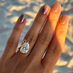 a woman's hand with a ring on it and a diamond in the middle