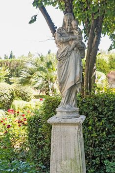 a statue is standing in front of some bushes