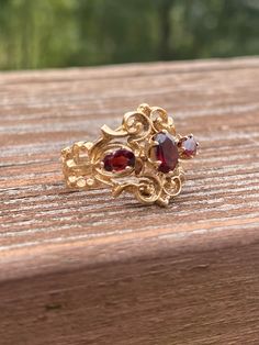 This ring is a bit more sold than most rings if this style.  It has a nice feel on the finger.  The 2 outside garnets measure 5mm x 3mm each and the center garnet measures 6mm x 4mm for an approx 1.05ctw. Please note that the garnets show signs of wear to the edges of the facets.  They are not overwhelming, and the stones still face up beautifully. We consider these imperfections as character to a ring of this age.  The ring weighs 4.7g and measures 16.25mm at its widest point. It is stamped 14k yellow gold. Size 7 and sizable.  We are happy to offer sizing for an additional charge. Let me know if you need a quote on sizing. Elegant Garnet Ruby Ring Stamped 14k, Heirloom Garnet Oval Birthstone Ring, Vintage Oval Garnet Birthstone Ring, Heirloom Oval Garnet Cluster Ring, Oval Garnet Ring Hallmarked, Formal Garnet Three-stone Rings, Formal Three Stone Garnet Rings, Formal Three-stone Garnet Rings, Victorian Oval Garnet Ruby Ring