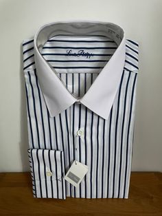 "Vintage unworn white shirt with dark blue stripes and solid white collar in polyester cotton mix by Louis Philippe of Savile Row.  Details: spread collar, long sleeves, single cuff, regular fit.  Size 15\" 38cm S/M" White Dress Shirt With Striped Collar For Work, White Cotton Dress Shirt With Striped Collar, Classic Shirt With Striped Cuffs And Spread Collar, White Shirt With Striped Collar For Work, Elegant White Shirt With Vertical Stripes, Elegant White Dress Shirt With Striped Collar, Semi-formal Striped Shirt With Striped Collar, Semi-formal Shirt With Striped Collar, Semi-formal Long-sleeved Shirt With Striped Collar