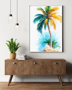 a painting hanging on the wall next to a wooden cabinet with two potted plants