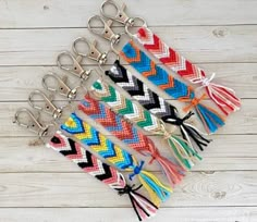 several pairs of multicolored chevron keychains with tassels on them