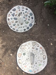 two white stepping stones sitting on top of dirt