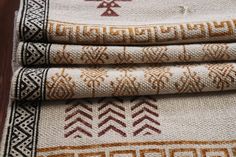 three pieces of fabric with different designs on them, one is white and the other is brown