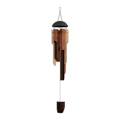 a wooden wind chime hanging from the side of a white wall with a black top