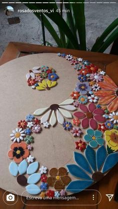 a paper plate with flowers on it and the letter s made out of different types of buttons