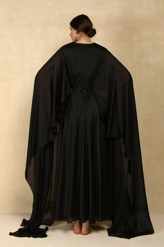 Colour : BlackFabric : Chiffon & Satin LiningDetails : Fitted, Cape Sleeve Floor Length Gown, Back Zip & Hook for Closure.Length : 59 inchesTHE MEASUREMENTS ARE IN INCHES Shoulder Bust Waist Low Waist Hips Armhole Extra Small 14 34 27 29 38 14 Small 14.5 36 29 31 40 15.5 Medium 15 38 31 33 42 16.5 Large 15.5 40 33 35 44 17.5 XL 16 42 35 37 46 18.5 XXL 17 44 37 39 48 19.5 Care• Dry Clean Only• Do Not Bleach• Steam Iron OnlyThis item is Made-To-Order. Please allow up to 21 working days for us to m Black Georgette Dress With Cape Sleeves, Black Cape Sleeve Festive Dresses, Black Fitted Gown With Cape Sleeves, Fitted Black Gown With Sheer Dupatta, Black Fitted Gown With Sheer Dupatta, Black Evening Gown With Sheer Dupatta, Black Gown With Sheer Dupatta For Evening, Fitted Black Abaya For Wedding, Black Georgette Gown With Sheer Dupatta