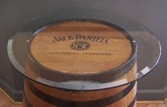 a wooden barrel sitting on top of a glass table with the name jack daniels written on it