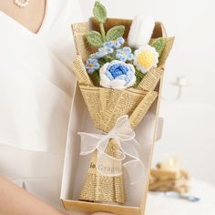 a person holding a box with flowers in it