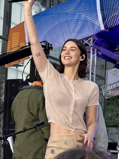 a woman holding an umbrella up in the air