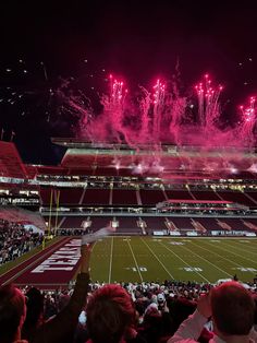 fireworks are lit up in the air above a football field