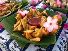 several plates of food on a table with pink flowers and sauce in the middle,