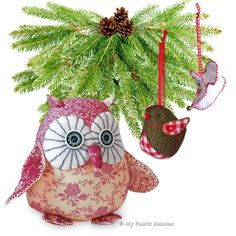 an owl ornament hanging from a christmas tree with pine cones on it's head