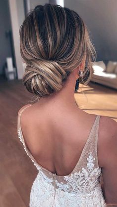 the back of a woman's head wearing a wedding dress in a living room