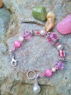 Handmade Pink Themed Women's Bracelet Featuring Large Pink Glass Beads, Lampwork Beads, Cat's Eye Beads, Rhinestone Rondelles, Freshwater Pearls, Glass Pearls, Glass Pearl Charm with Silver Spacers and Clasp.  This would Make the Perfect Gift for a Teenage Girl or Lady Who loves Pink. Thank You for Looking! Please Message Me with any Questions. Bead Colors: Pink White Silver **Not Suitable for Young Children.     Beads Present a Possible Choking Hazard. Handcrafted Bracelets, Eye Beads, Pearl Charms, Pink Glass, Lampwork Beads, White Silver, Jewelry Ideas, Womens Bracelets, Fresh Water