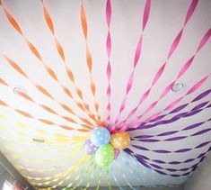 the ceiling is decorated with colorful striped paper straws and balloons on top of it