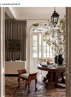 a dining room with a table, chairs and vases on top of the table