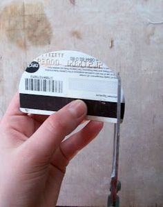 a hand holding a small white and black object with a barcode on it's side