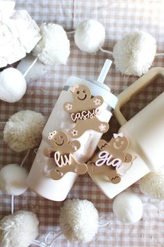 a baby bottle and its contents on a table with pom poms in the background