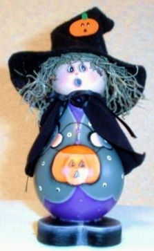 a purple and black pumpkin with a witch hat on it's head sitting on top of a blue ball