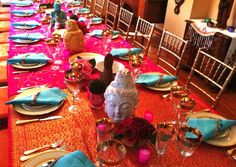 the table is set with plates, silverware, and buddha head napkins on it