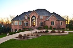 a large brick house with landscaping in front