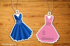 two paper dresses hang from strings on a wooden background with the words dress for prom written in blue and pink