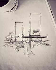 a pencil drawing of a bridge and trees on top of a piece of paper next to a coffee cup