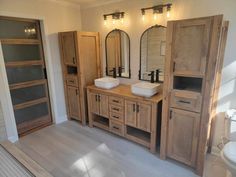 a bathroom with two sinks, cabinets and lights on the wall in it's center