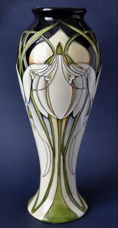 a white and green vase sitting on top of a table