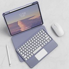 an open laptop computer sitting on top of a white table next to a mouse and keyboard