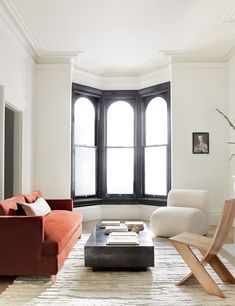 a living room filled with furniture and a fire place in front of a large window