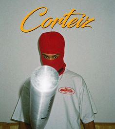 a man wearing a red mask and holding a white object in his hand with the word contex on it