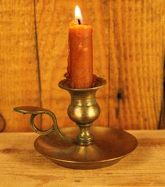 a lit candle sitting on top of a metal stand