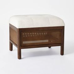 the foot stool is made out of wood and has a white upholstered cushion