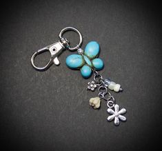 a pair of scissors is attached to a keychain with beads and charms on it