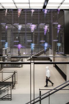 a person walking down some stairs in front of a large screen