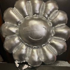 a silver flower shaped pillow sitting on top of a table