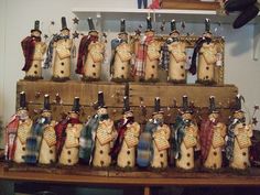 many snowmen are hanging on the wall in front of a shelf with other decorations