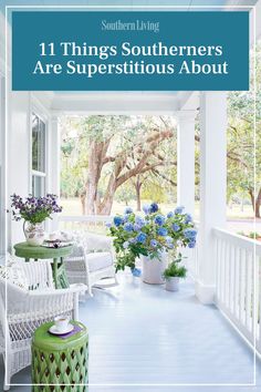 the front porch with white wicker furniture and blue flowers in vases on it