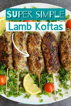 lamb koftas on skewers with lemons and tomatoes