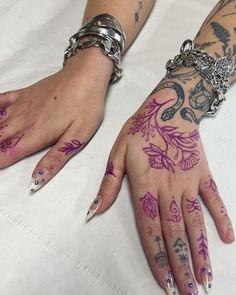 two hands with tattoos on them are sitting on a white sheet and one is holding onto the other hand