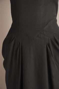 "Vintage 1950s jet black cocktail party dress with wonderful glass beading throughout. This vintage dress features a flattering fitted bodice with bust darts, nipped waist, and a lovely draped skirt. There is a back metal zipper for closure. ✂------ M E A S U R E M E N T S ------- Best Fit: Medium Bust: 37.5\" Waist: 29.5/30\" Hips: 42\" Shoulders: undefined Sleeves: 4.5\" Total Length: 49.5\" Material: rayon Condition: Excellent vintage condition. Ready to wear. ☆ Layaway is available for this Fitted Black Dress With Pleated Waist, Black Fitted Dress With Pleated Waist, 1950s Fitted Black Dress, Black Fitted 1950s Style Dress, Fitted Black 1950s Dress, Fitted Black Dress In 1950s Style, Fitted Black Dress 1950s Style, Black Dress With Fitted Waist For Evening, Fitted Tea-length Lined Dress