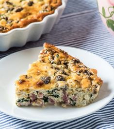 a slice of quiche on a plate next to a casserole dish