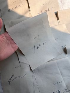 a hand is holding several pieces of paper with writing on them