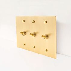 four brass knobs are mounted on the wall to create a unique display for your home