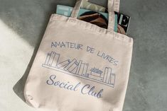 Book Lover Tote Bag - Amateur de Livres Social Club - Cute French Bookworm Canvas Bag - Literary Gift - Bookish Tote for Readers - Book Tote Elevate your everyday style with our 100% Cotton Canvas Tote Bag, the perfect blend of durability and chic design. Whether you're headed to the farmer's market, the beach, or just running errands, this spacious 15" x 16" bag is your go-to companion. Crafted from heavy 12 oz/yd² (406.9 g/m²) cotton canvas, it's built to handle anything life throws your way, while the vibrant prints ensure you stand out in any crowd. The sturdy 20" handles, made from the same durable canvas, offer a comfortable grip and make it easy to carry even your heaviest hauls. With its sleek and practical design, this tote bag is not just a stylish accessory but also a sustainabl Literary Gifts, Social Club, Book Lover, Vibrant Prints, Chic Design, Everyday Style, Stylish Accessories, Canvas Bag, Plastic Bag