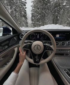 the interior of a mercedes s - class coupe driving on a snowy road with trees in the background